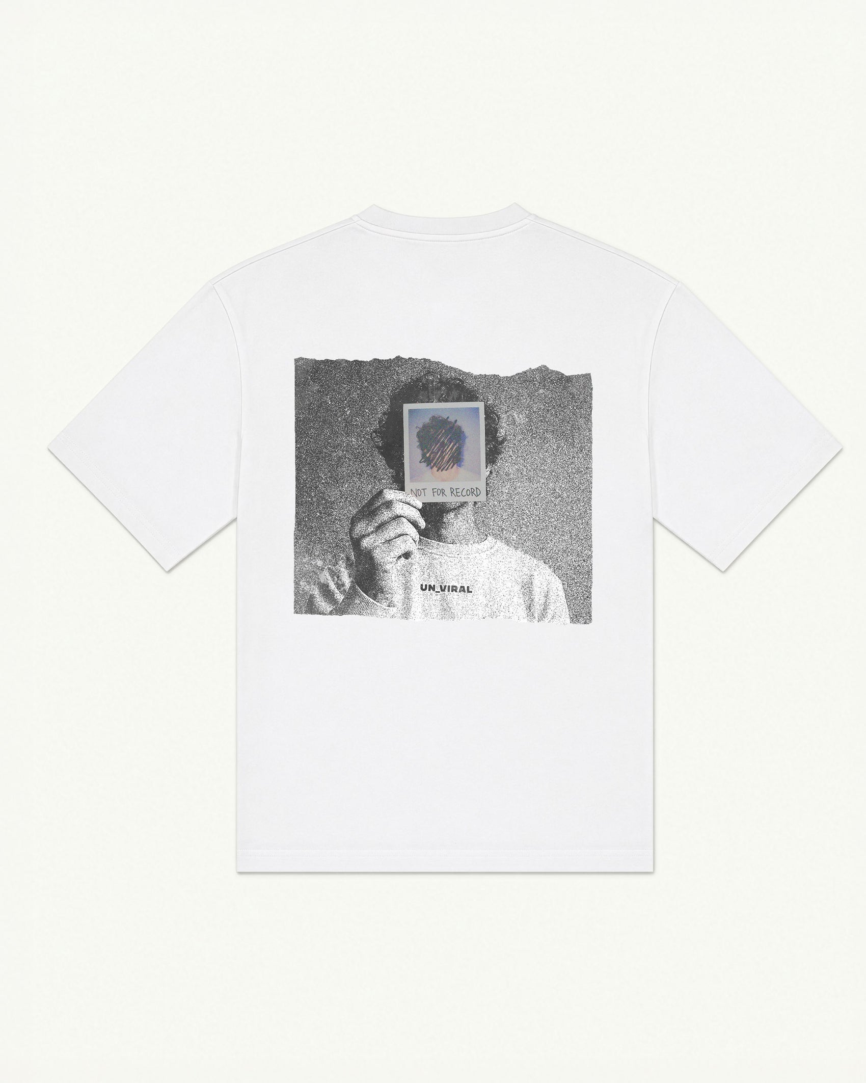 White oversized UNVIRAL t-shirt with a grainy back-print photograph, a hand holding a polaroid labeled not for record over a face