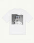 White oversized UNVIRAL t-shirt with a grainy back-print photograph, a hand holding a polaroid labeled not for record over a face
