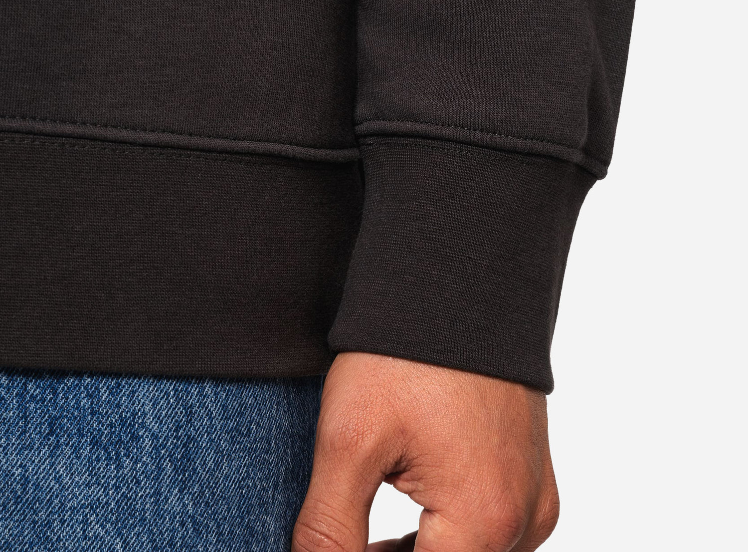 Close-up of UN VIRAL sweatshirt ribbed cuff and double-stitched construction.