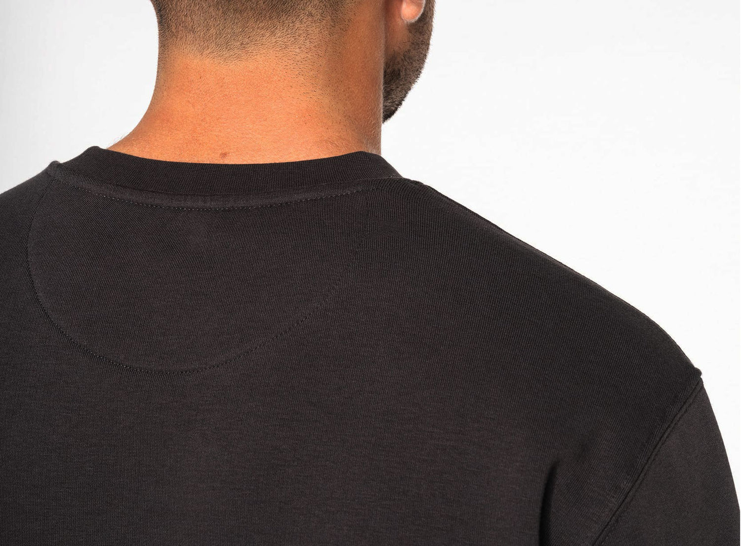 Back view of UNVIRAL sweatshirt showing tubular-knit collar and reinforced neckline.